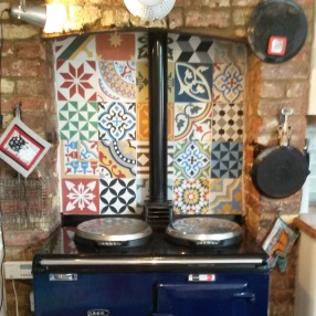 Encaustic tiles behind a hob in the kitchen