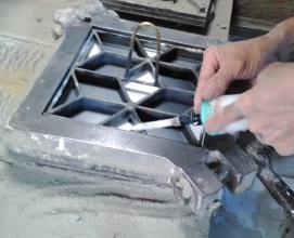 Production of encaustic tiles. The cement mixture is poured into the metall grill.