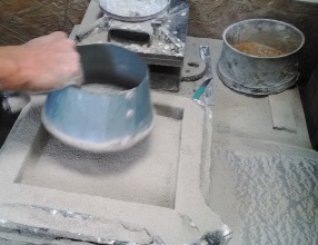 Production of encaustic tiles. The metall grill is taken out of the mould.